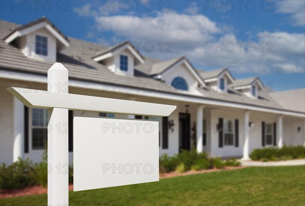 Blank real estate sign in front of new house