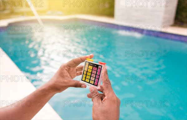 Maintenance person showing a pool ph and chlorine tester kit