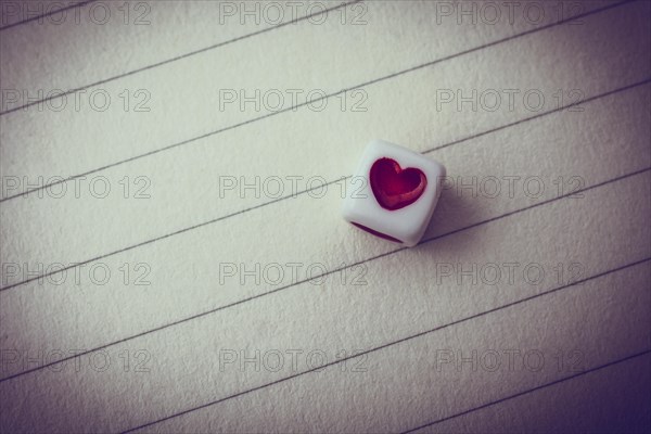 Colorful cube with a heart placed on paper