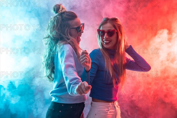 Two young blonde caucasian women dancing in nightclub