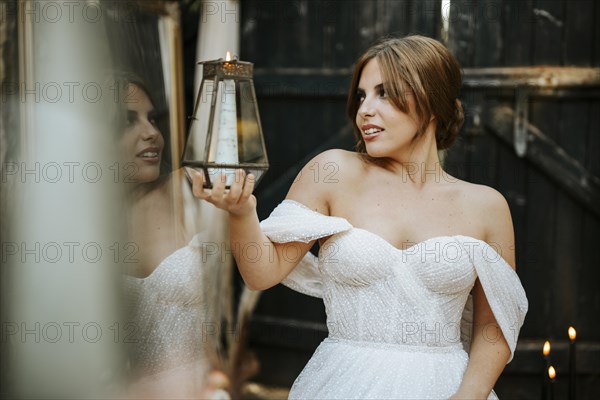 Portrait of beautiful bride holding lantern in rustic background