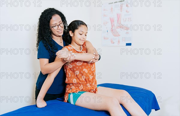Physiotherapist woman rehabilitating the arm of a patient. African american physiotherapist evaluating arm of female patient