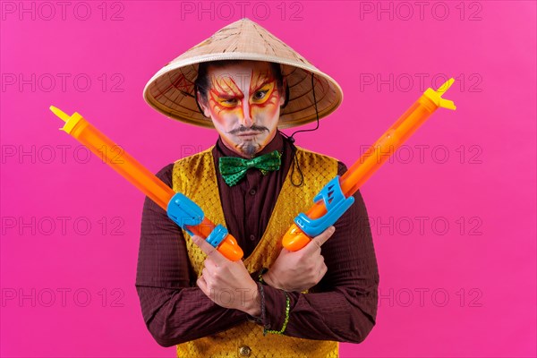 Clown with white facial makeup on a pink background