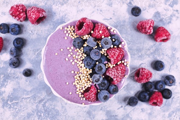 Top view of healthy yogurt and fruit smoothie bowl decorated with raspberry