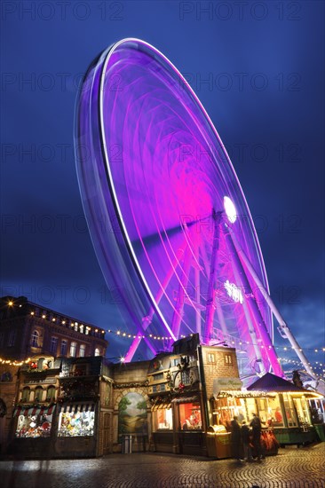 Rhine promenade with Castle Tower and illuminated Ferris wheel at dusk