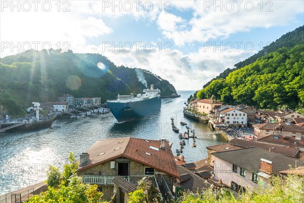 Entrance of a giant merchandise ship in the bay of Pasaia to the open sea Pasajes