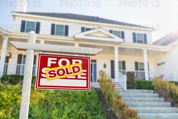 Sold for sale real estate sign in front of new house