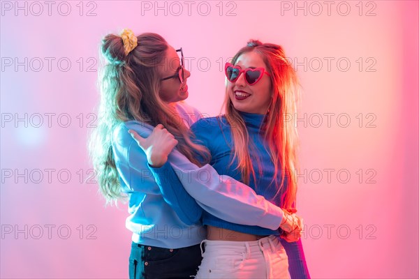 Two young blonde caucasian women dancing in nightclub