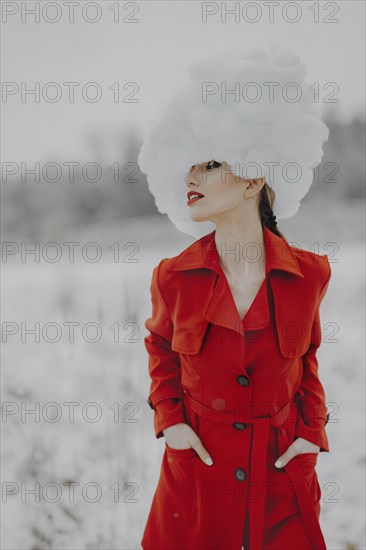 Woman in red coat with cloud on her head in the snow