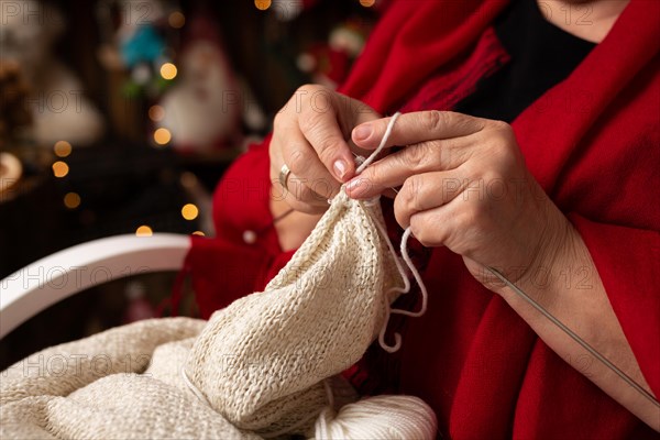 Grandmother sews a plush owl in Christmas arrangement. In studio