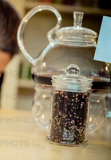 Herbal tea brewed in glass teapot and tea plant in a bottle