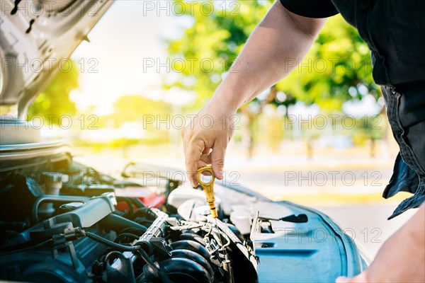 Man hand checking oil to car with copy space. People hand inspecting car oil level. Driver hand inspecting car oil level