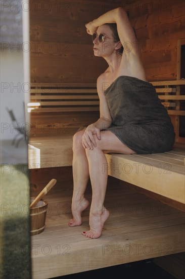 Woman sitting in Finnish sauna