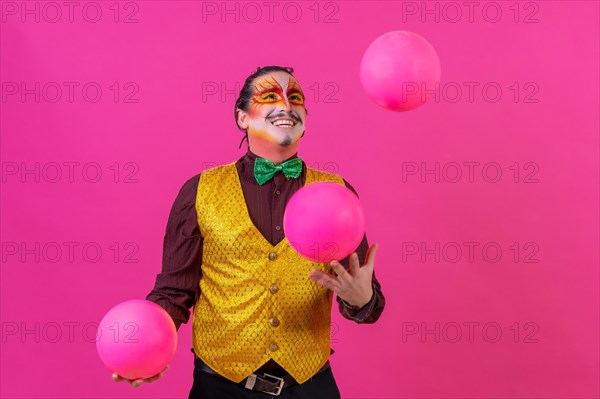 Clown with white facial makeup on a pink background