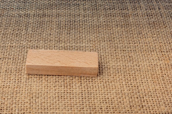 Wooden domino on a linen canvas background