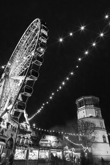 Rhine promenade with Castle Tower and illuminated Ferris wheel at dusk