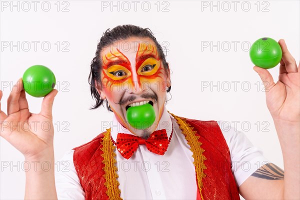Portrait of smiling juggler juggling green balls isolated on white background