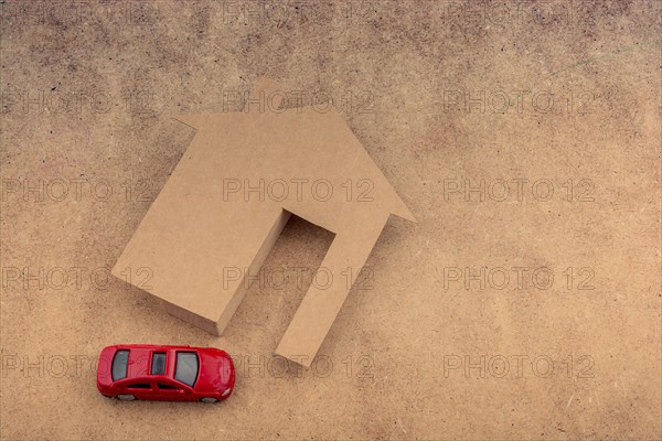 Paper house and a model car on a canvas background