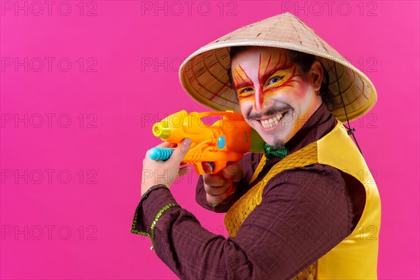 Clown with white facial makeup on a pink background