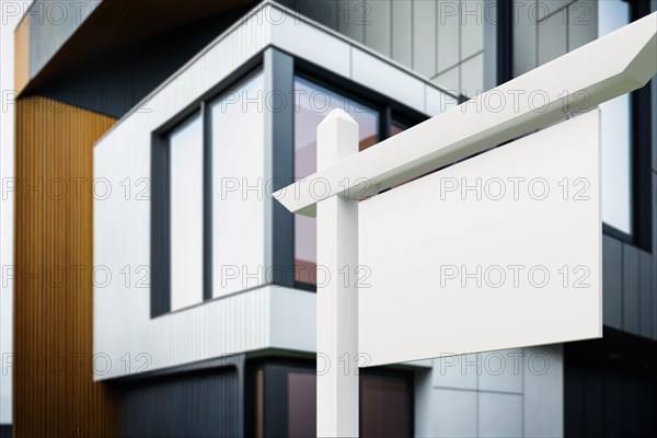 Blank real estate sign in front of new contemporary house