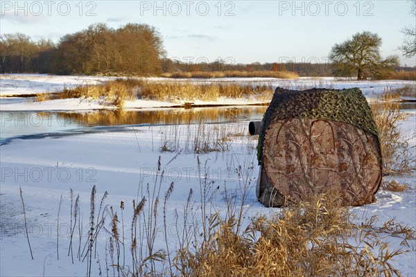 Camouflage tent of a nature photographer on an ice rink