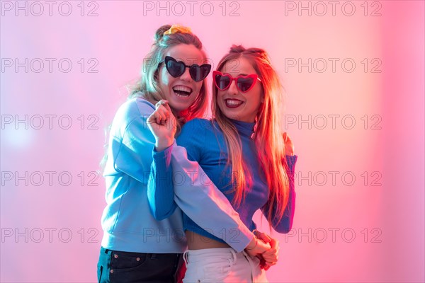 Two young blonde caucasian women dancing in nightclub