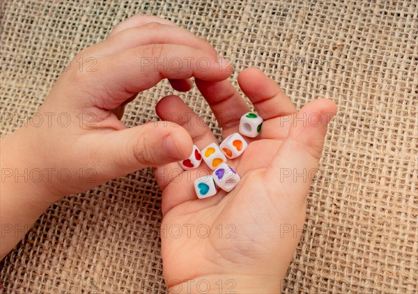 Little cubes with heart shape in hand on canvas