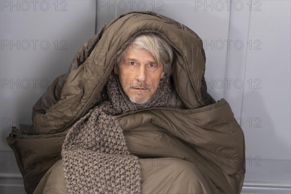 Elderly gentleman freezing in sleeping bag