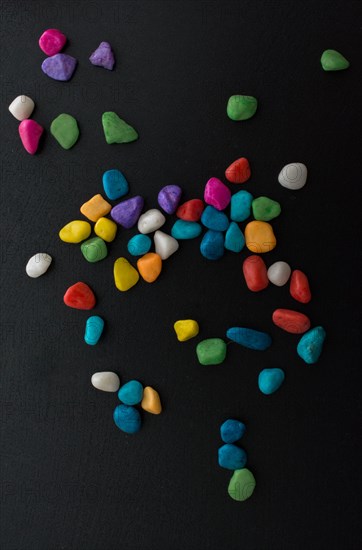 Pile of little colorful pebbles on black background