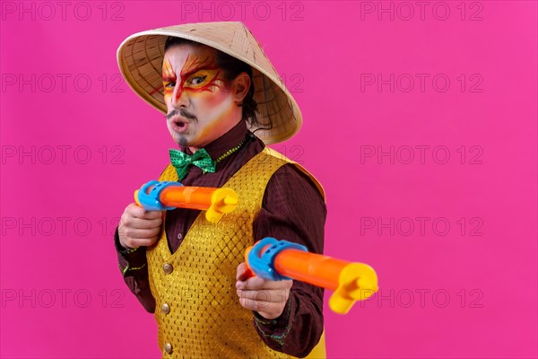 Clown with white facial makeup on a pink background