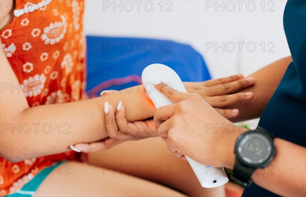 Modern laser physiotherapy on woman patient. Laser therapy used on the arm to treat pain