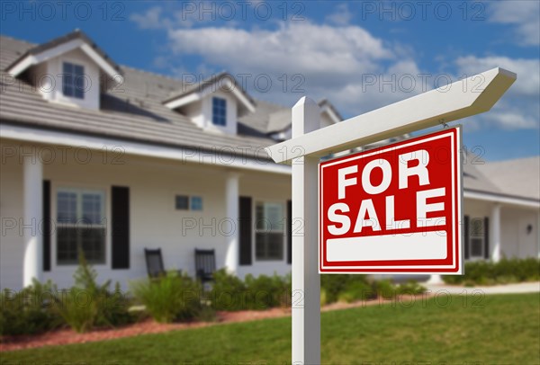 For sale real estate sign in front of new house