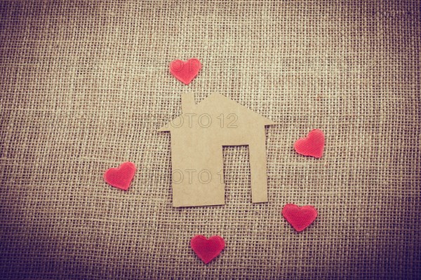 Heart shape around the paper house with a canvas background