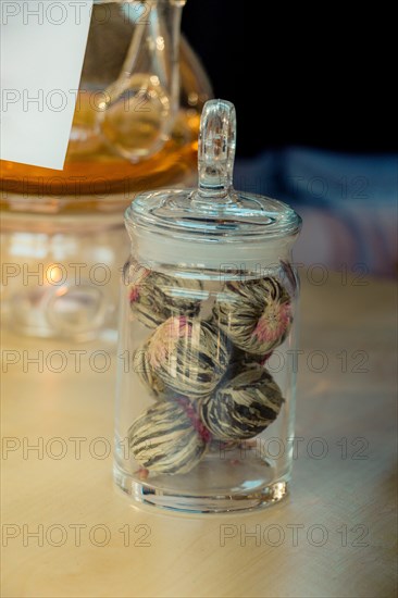 Herbal tea brewed in glass teapot and tea plant in a bottle