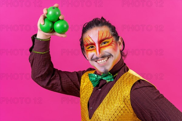 Clown with white facial makeup on a pink background