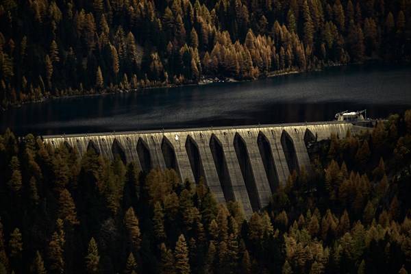 Dam of the Zufrittsee with autumnal mountain forest