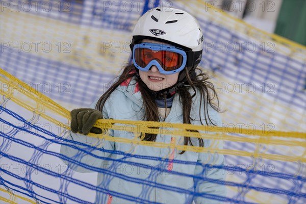Girl skiing with helmet and ski goggles