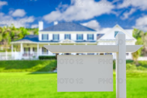 Blank real estate sign in front of new house