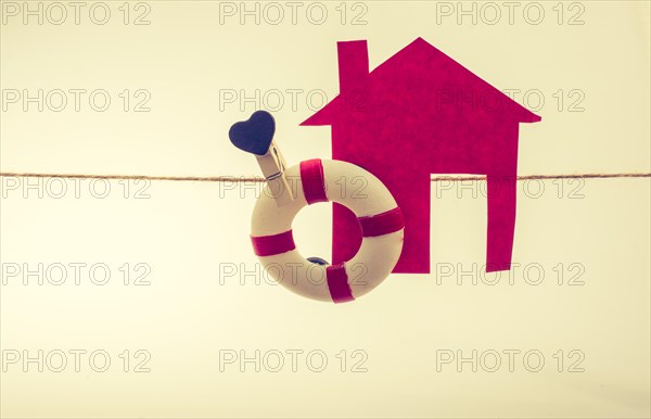 Model house and a life preserver with a heart on a string