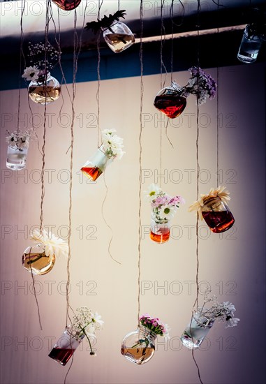 Herbal tea bottles with flowers hanging on strings
