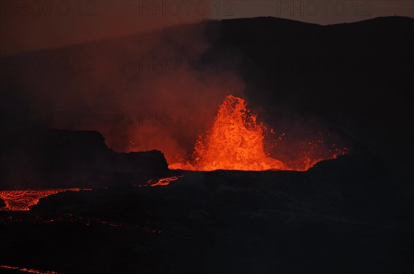 Active volcano spewing lava into the sky