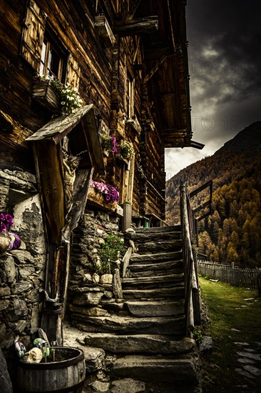 Alpine hut in autumnal mountain landscape with threatening cloudy sky