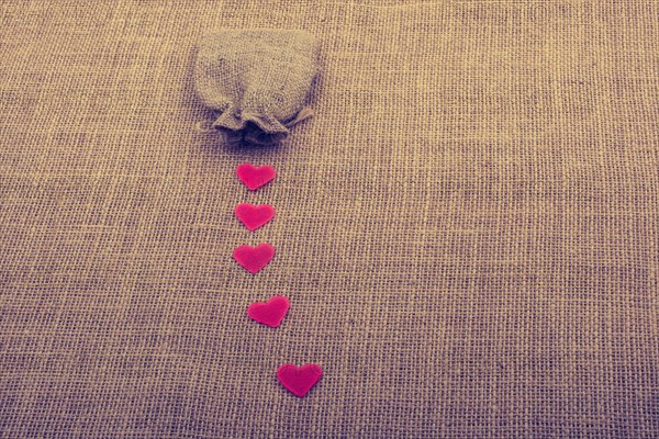 Heart shaped objects before a sack on canvas
