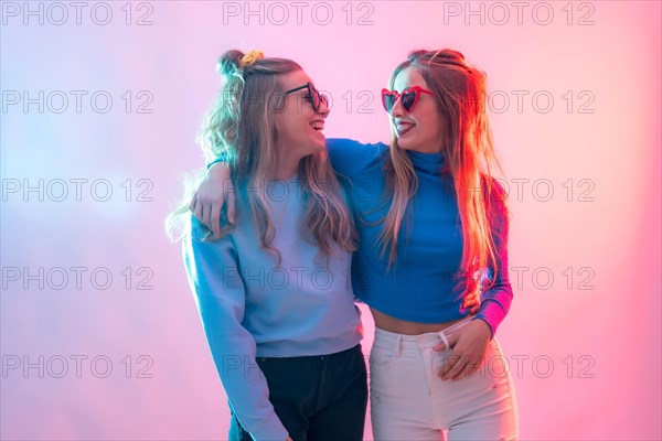 Two young blonde caucasian women dancing in disco