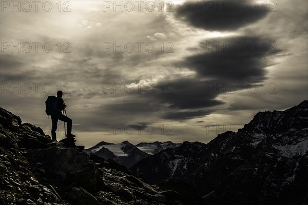 Climbers on rocks in backlight with cloudy sky in the background South Tyrolean mountains