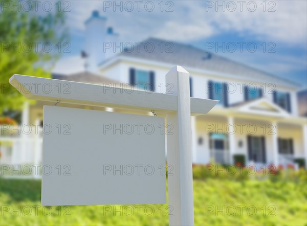 Blank real estate sign in front of new house