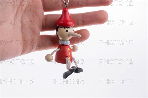 Wooden pinocchio doll with his long nose on a white background