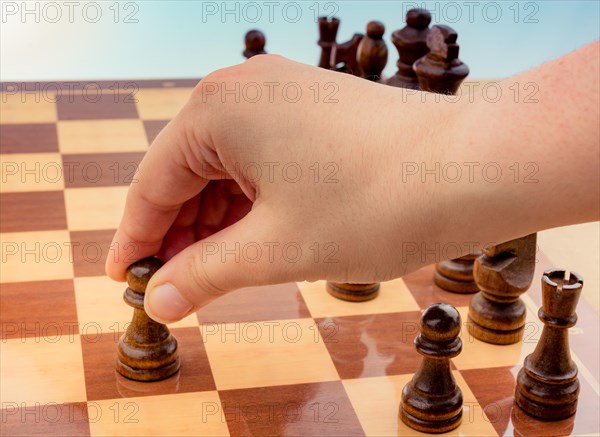 Person playing chess game making a move on board