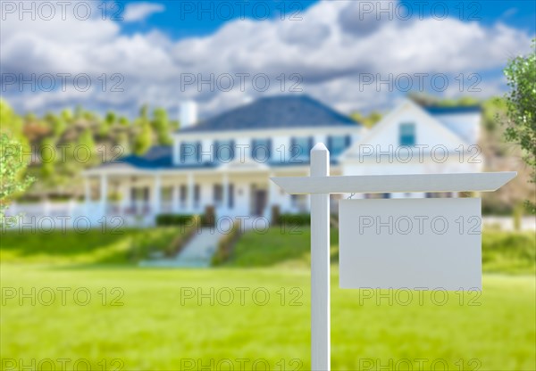 Blank real estate sign in front of new house