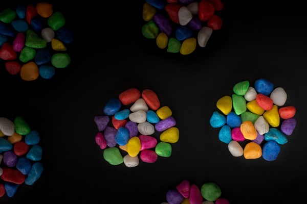 Pile of little colorful pebbles on black background